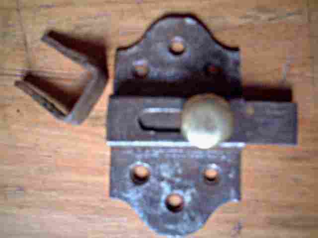 Ancien verrou en fer forgé, avec un bouton en cuivre.