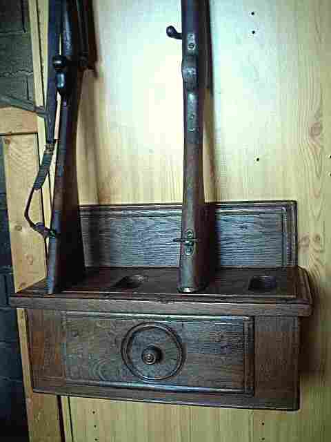 Un porte fusil en bois ancien, style art populaire pouvant contenir 4 fusils, avec tiroir et boites secrètes sur les cotés.