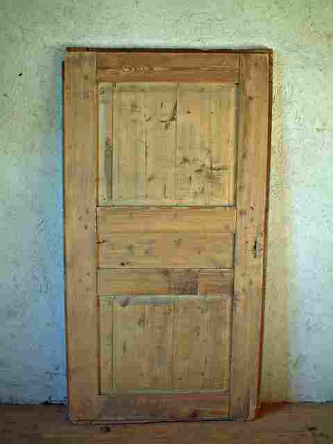 Une porte large en sapin et tilleul, 3 panneaux rustique à restaurer.